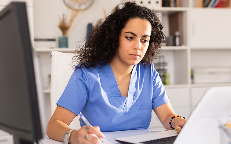 Practitioner completing regitration on a laptop