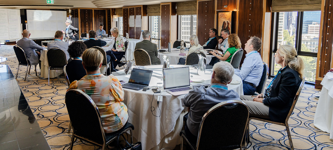 Photo of board members at a conference watching a presentation